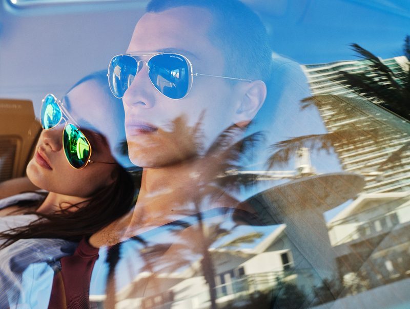Coppia in auto con occhiali aviator specchiati Dolce&Gabbana x Ray-Ban