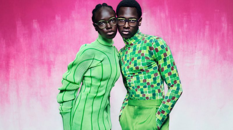 Due modelli in verde con occhiali da vista Etnia Barcelona su sfondo rosa