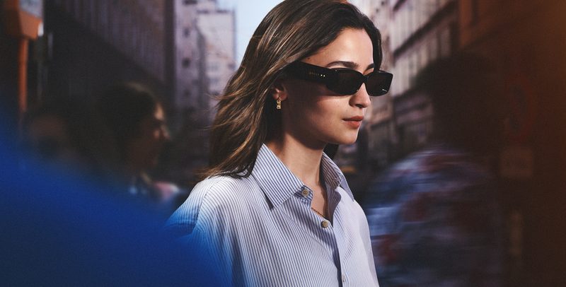 Donna con occhiali da sole Gucci rettangolari neri in una strada di Milano