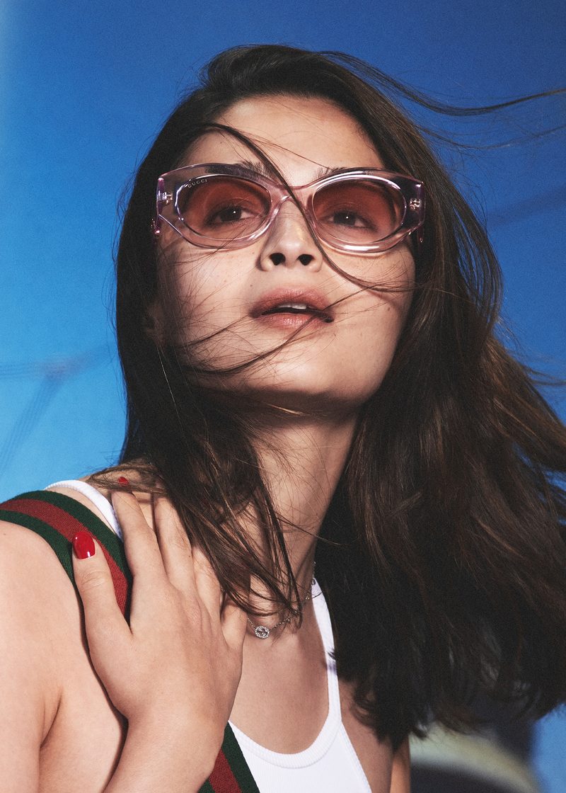 Donna con occhiali da sole Gucci cat-eye rosa trasparenti contro il cielo