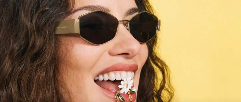 Donna sorridente con occhiali da sole Marc Jacobs esagonali dorati
