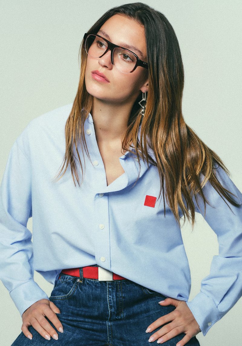 Modella con occhiali da vista MAX&Co. e camicia azzurra