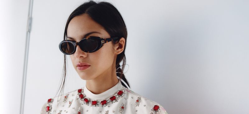 Donna con occhiali da sole Miu Miu ovali neri e top ricamato