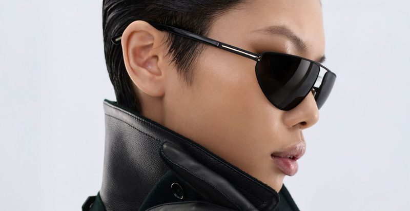 Donna con occhiali da sole Tom Ford neri affusolati e cappotto di pelle